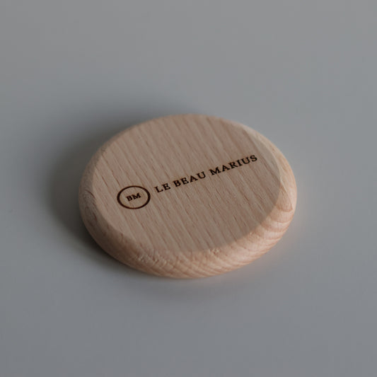 Décapsuleur aimanté en hêtre Ø 65 mm gravé du logo Le Beau Marius, vue de trois quarts
